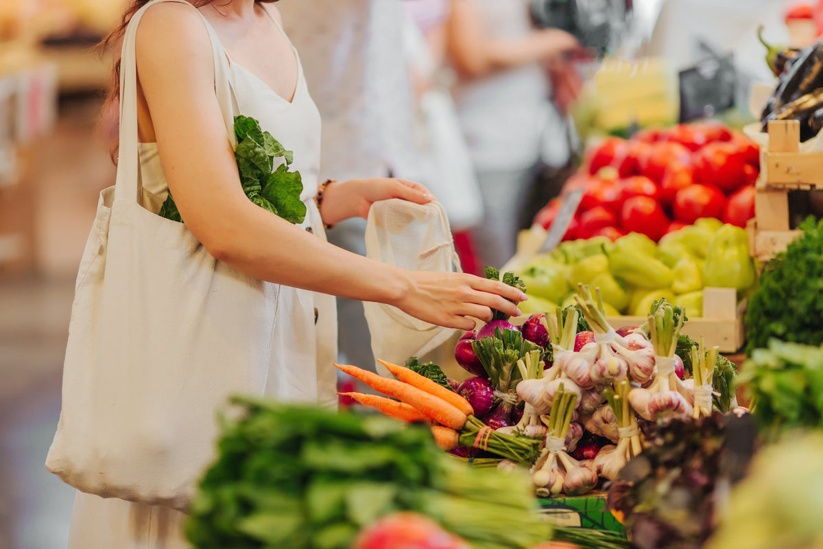 Man sieht eine Frau die basische Lebensmittel auf einem Markt einkauft