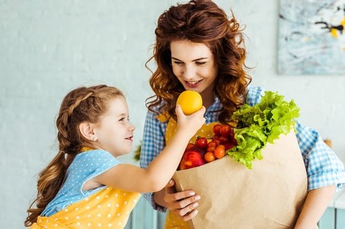 Obst und Gemüse sind ein wichtiger Teil einer gesunden Ernährung für Kinder Mama und Tochter kreieren zusammen eine ausgewogene Familienmahlzeit