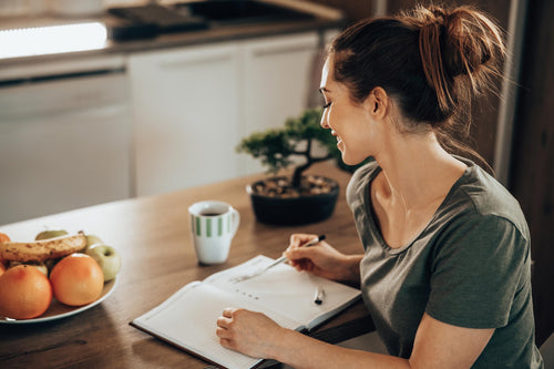 Struktur statt Stress dank To-do-Listen Junge Frau notiert sich all ihre Aufgaben in einer To-do-Liste